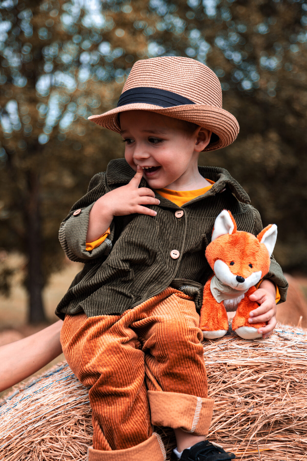 Enfant sur botte de paille avec veste et pantalon