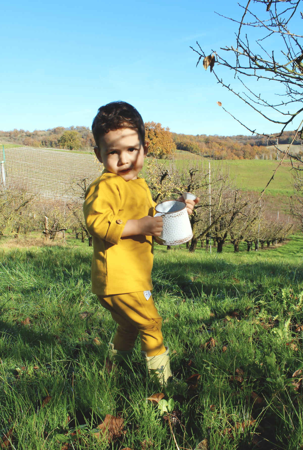 enfant dans les champs avec ensemble jaune moutarde